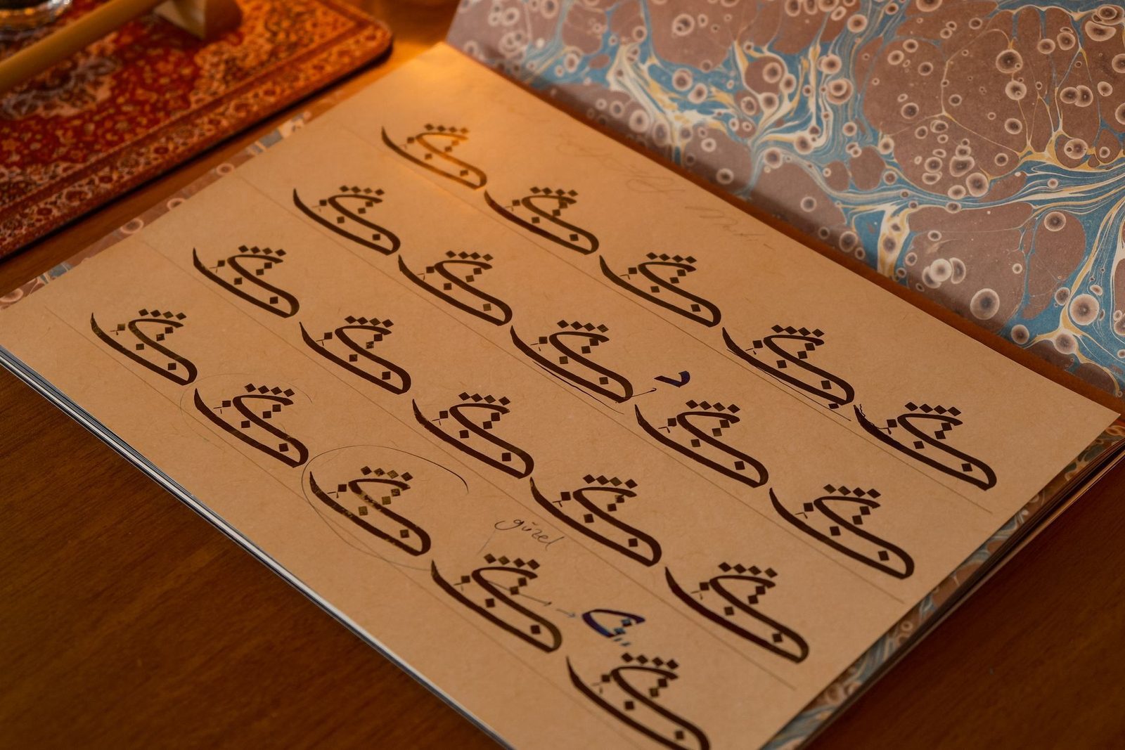 Cahier ouvert sur une table de riad avec un calame et une tasse de thé