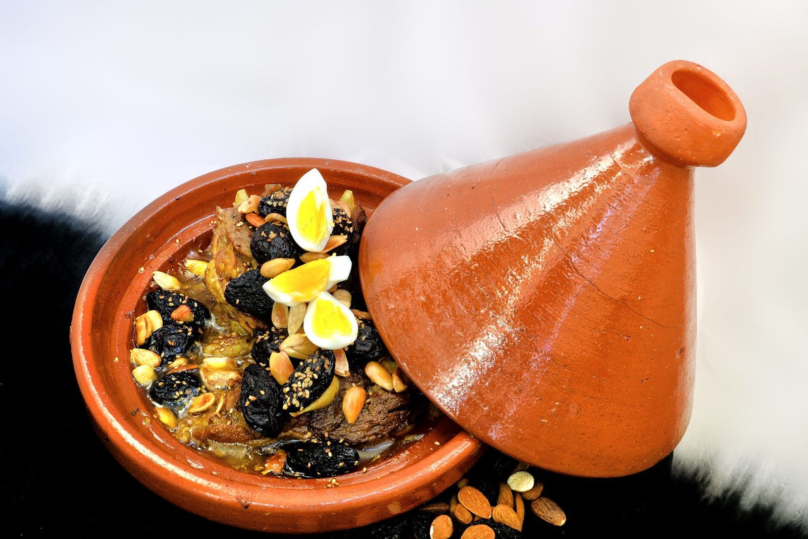 Table marocaine dressée avec tajine fumant, salades et pain traditionnel